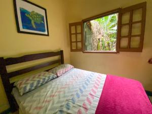 a bedroom with a bed and a window at Sintonia Surf Hostel e Bar in Ubatuba