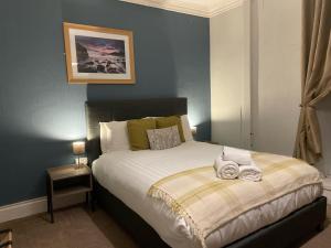 a bedroom with a large bed with white sheets at Prince Llewelyn Hotel in Beddgelert