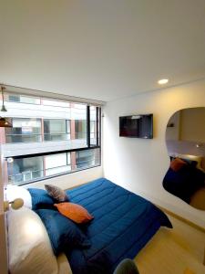 1 dormitorio con 1 cama grande y ventana grande en Loft Club House Chapinero, en Bogotá