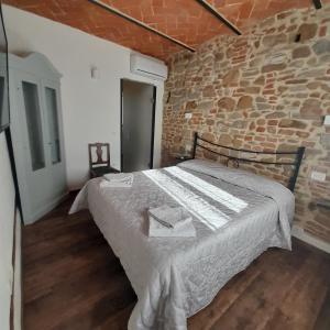 een slaapkamer met een groot bed in een bakstenen muur bij piccolo Garibaldi appartamento in Arezzo