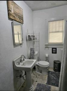 Baño blanco con lavabo y aseo en The Bungalow, en Seymour