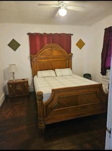The Bungalow في Seymour: غرفة نوم بسرير خشبي كبير مع ستارة حمراء