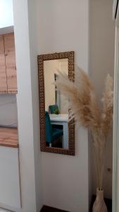 a mirror on a wall with a blue chair and a table at Apartment BN MAGIC in Bijeljina