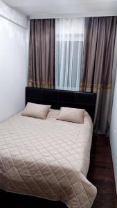 a bed with two pillows on it in a bedroom at Apartment BN MAGIC in Bijeljina