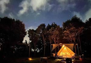 ein Zelt auf einem Feld in der Nacht mit Bäumen in der Unterkunft Katsuyama Basecamp - Camp - Vacation STAY 42349v in Yamanuha