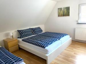 a bedroom with a bed with blue and white sheets at Haus Seeblick in Allersberg