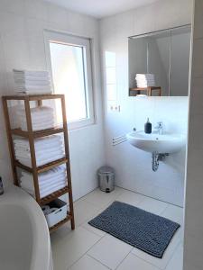 a white bathroom with a sink and a mirror at Haus Seeblick in Allersberg