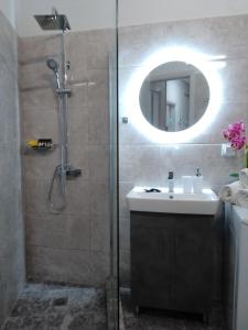 a bathroom with a shower and a sink and a mirror at Volos Hospitality, Central Apartment in Volos