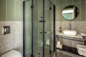 y baño con ducha acristalada y lavamanos. en Savanna Dizengoff - Smart Hotel by Loginn Tel Aviv, en Tel Aviv