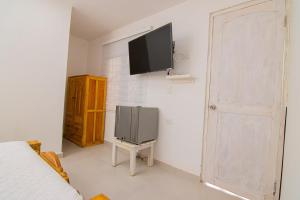 a bedroom with a tv on the wall and a bed at CASA PLAYA JAMES in Los Arrayanes