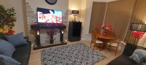 ein Wohnzimmer mit einem Sofa, einem Tisch und einem TV in der Unterkunft OLIVE TREE - 2 Master bedroom (sleeps 6) in Blackpool