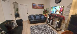 a living room with a couch and a fireplace at OLIVE TREE - 2 Master bedroom (sleeps 6) in Blackpool