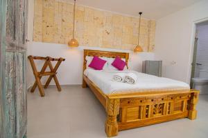 a bedroom with a wooden bed with pink pillows at CASA PLAYA JAMES in Los Arrayanes