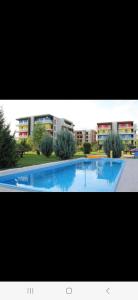 a large swimming pool in front of a building at Golden Airport Residence in Otopeni