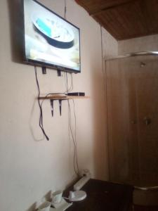 a flat screen tv hanging on a wall in a bathroom at Nafi guest house in Phuthaditjhaba