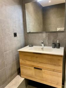 a bathroom with a sink and a mirror at Appartement rénové T2, vue montagne in Samoëns