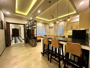 a kitchen with a bar and a living room at COMFORT & LUXURY HOME in Islamabad