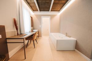 a bathroom with a desk and a bath tub at Casa Pelegrí in Morella