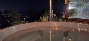a bath tub sitting on a balcony at night at Trout Cottage in Bran