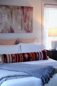 朗蒙特的住宿－Enjoy Mountain Views, Fully Equipped 2BR Farmhouse，一张带枕头的白色床和墙上的绘画
