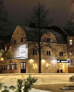 un bâtiment avec un arbre devant lui la nuit dans l'établissement Hotell Esplanad, à Växjö