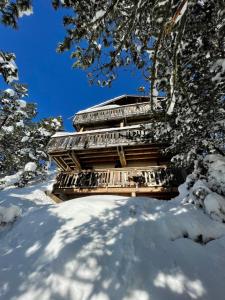 een gebouw in de sneeuw met sneeuw bedekte bomen bij Chalet en cascade Les Angles vue Panoramique in Les Angles