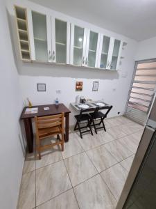 a kitchen with a table and chairs in a room at Studio Ideal in São Paulo