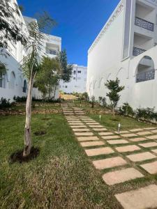 a tree in the grass next to a building at Your privat peace place in Tangier