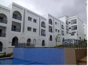 a large white building with a pool in front of it at Velvet View Tangier in Tangier