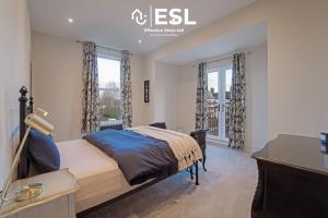 sypialnia z łóżkiem, biurkiem i oknami w obiekcie Stunning 4 bedroom home w mieście Chester