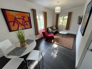uma sala de estar com uma mesa e uma cadeira vermelha em Cozy 2 bedroom flat Tower Bridge / Bermondsey em Londres