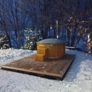 bañera de hidromasaje en una terraza de madera en la nieve en Agroturystyka Eko-Łysogóry, gorąca balia GRATIS!!!, en Huta Szklana