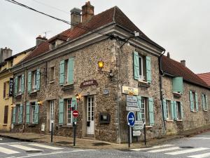 un antiguo edificio de piedra en la esquina de una calle en L'Harmony en Saint-Arnoult-en-Yvelines