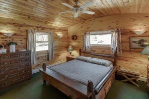- une chambre avec un lit dans une cabane en rondins dans l'établissement Two Lakefront Whitefish Chain Cabins for price of one, à Cross Lake
