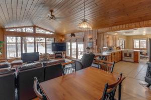 Il comprend une cuisine et un salon avec une table et des chaises. dans l'établissement Two Lakefront Whitefish Chain Cabins for price of one, à Cross Lake