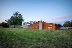 een houten huis in een veld met een grasveld bij The Charming Cowboy House in Ellensburg