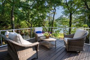 two chairs and a table on a deck with trees at Relax on Lake Michigan at Tranquil Shores in Norton Shores