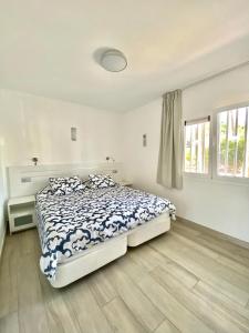 a white bedroom with a bed and a window at Sofia23 in Costa Calma