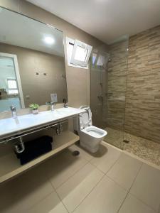 a bathroom with a toilet and a sink and a shower at Sofia23 in Costa Calma