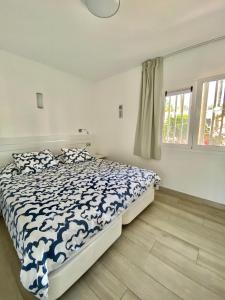 a bedroom with a bed with a blue and white comforter at Sofia23 in Costa Calma