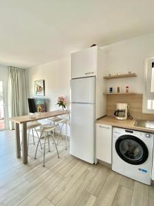 a kitchen with a white refrigerator and a table at Sofia23 in Costa Calma