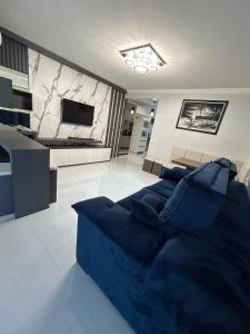 a living room with a blue couch and a tv at Apartamento 603, lindo, climatizado, completo in Piratuba