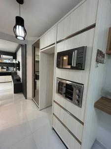 a kitchen with a wall with a microwave at Apartamento 603, lindo, climatizado, completo in Piratuba