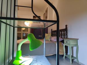 ein Schlafzimmer mit einem Bett und einer grünen Lampe in der Unterkunft Casa Albergo Rende in Quattromiglio
