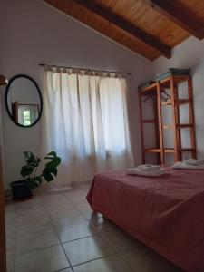 a bedroom with a bed and a mirror and a window at Cabañas Mérida Hollywood in El Hoyo