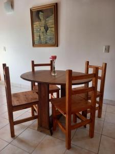 a wooden table and chairs with a vase of flowers on it at Cabañas Mérida Hollywood in El Hoyo