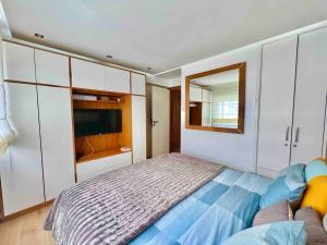 a bedroom with a bed and a television in it at Appartement pieds dans l’eau M’diq in M'diq