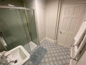 a bathroom with a shower and a sink and a door at The Windsor Room With Private Bathroom in Windsor