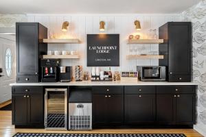 a kitchen with black cabinets and a counter with appliances at Launchpoint Lodge: Entire Hotel in Lincoln