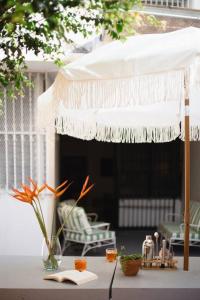 una mesa con un paraguas blanco y un libro en Architect’s tropical apt with beautifull garden en Panamá